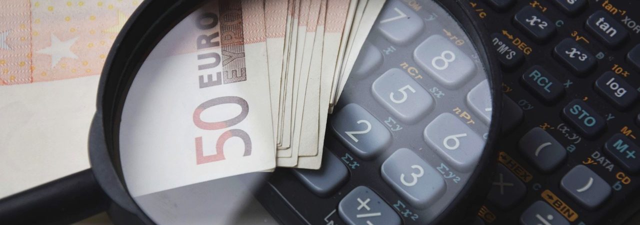 Banknoty euro, kalkulator i lupa symbolizujące analizę finansową przy obliczaniu alimentów.