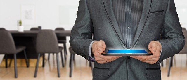 mężczyzna z tabletem na sali konferencyjnej