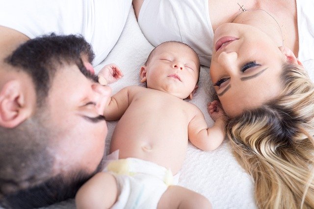 Mama i tata leżą z dzieckiem